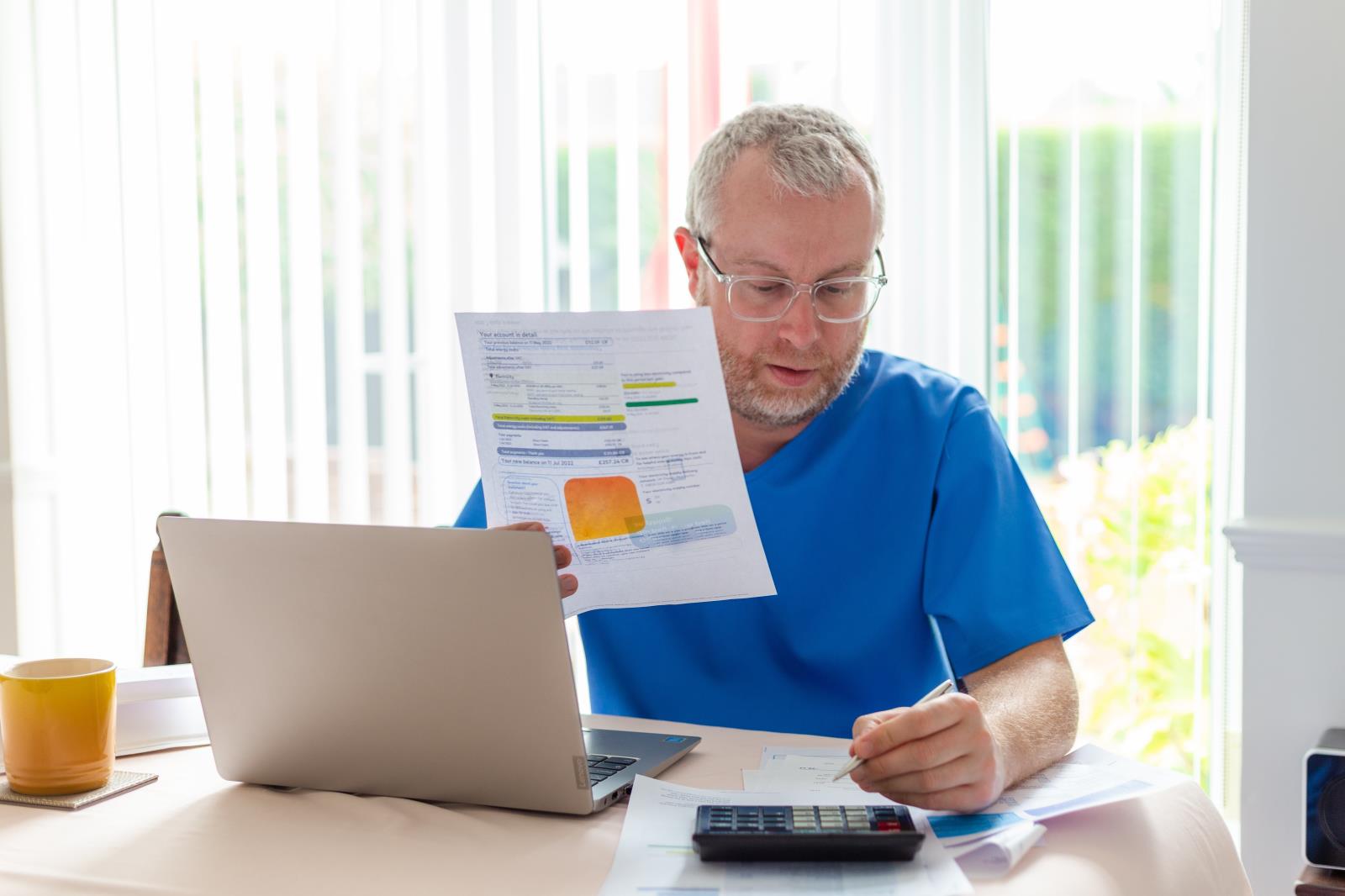 Man looking at his bills in a kitchen dinning room.