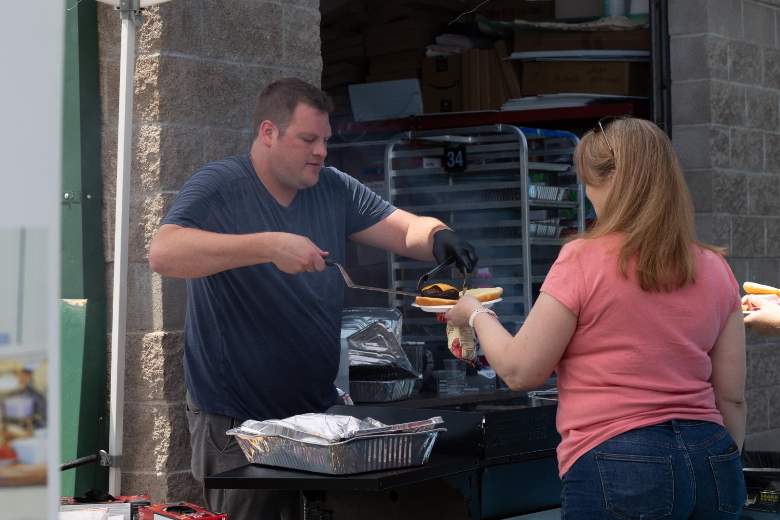 Person serving aburger during the SCC BBQ.