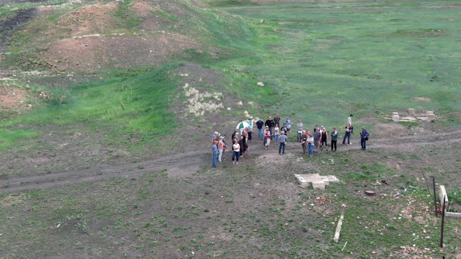 Ariel drone view of Boulder County Open Space, a group of 35 people on a tour, and visible concrete building foundation remnants.