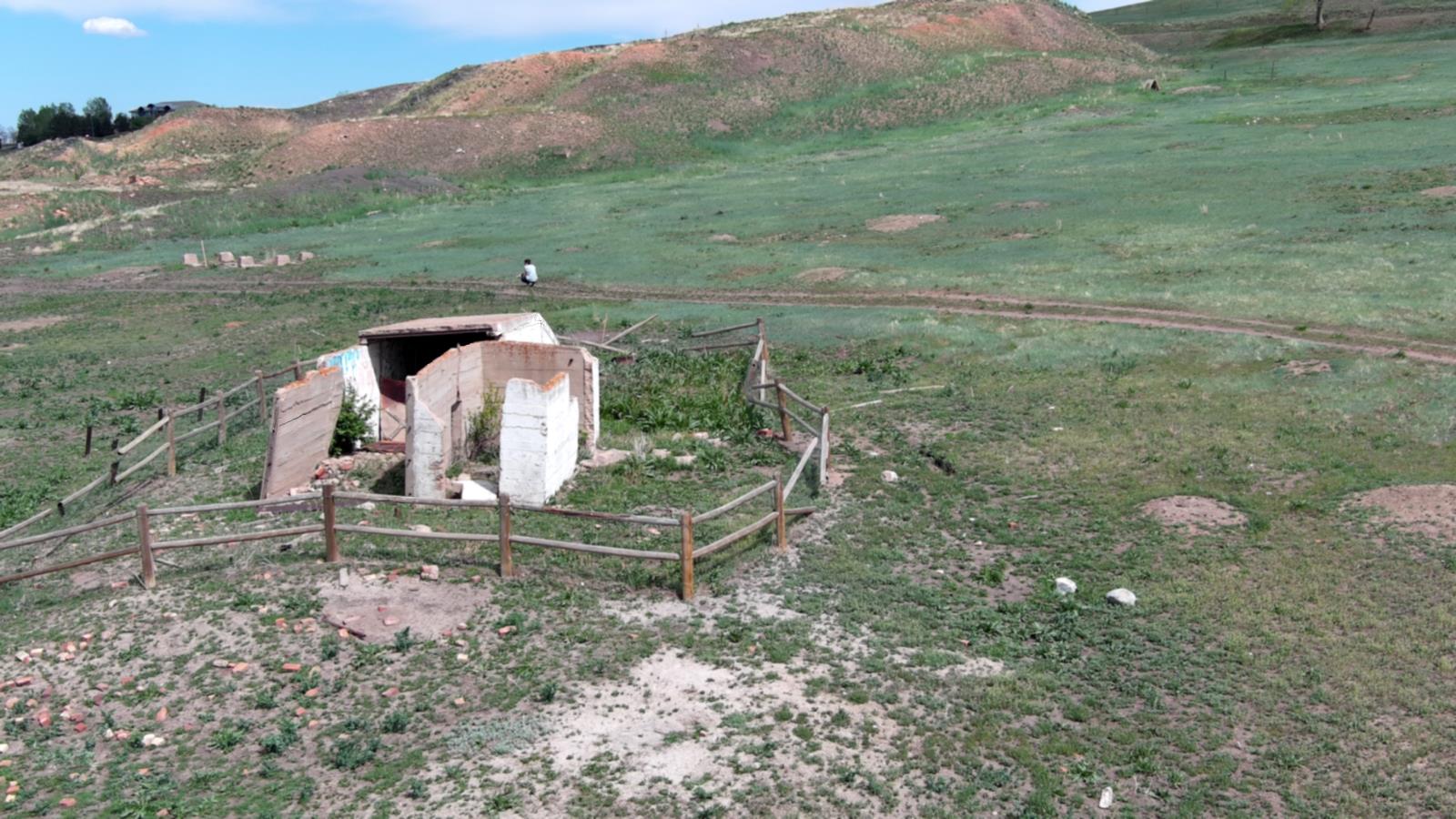 Ariel drone view of Boulder County Open Space, visible concrete building foundation remnants, rectangular in shape. A split rail fence surround the structure.