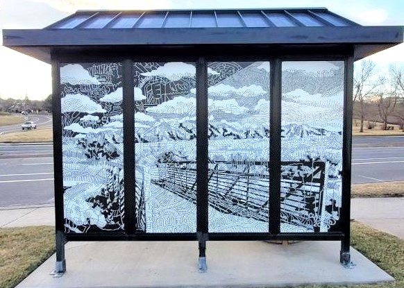 Backdrop to a bus shelter has four glass pane windows. Artwork imagery in each panel create the illusion of one large black and white drawing of a bridge and mountainous landscape.