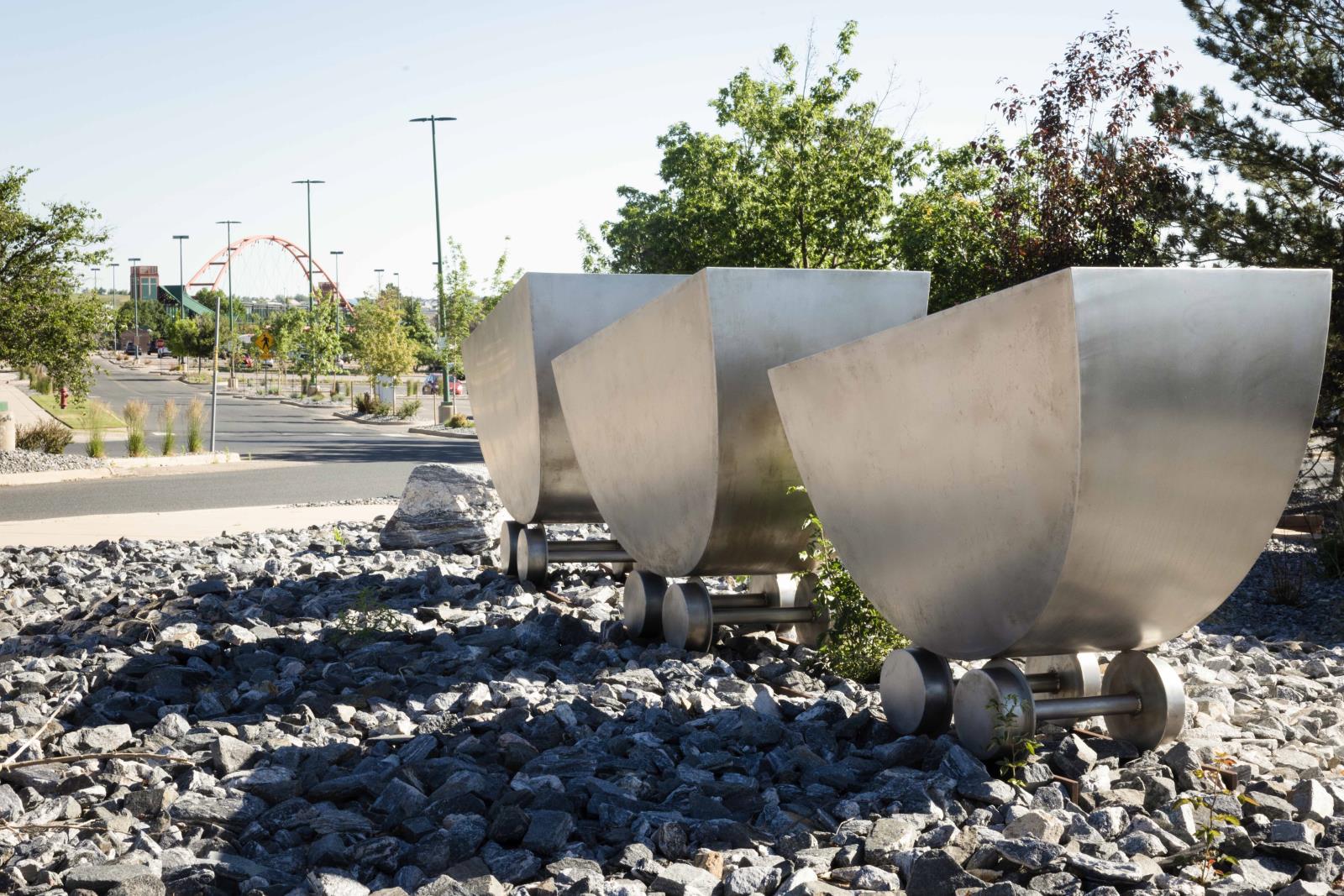 Silver coal cart Sculptors that sit in the Superior Marketplace.